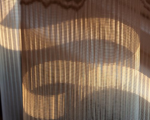 Desk near a window with sheer curtains